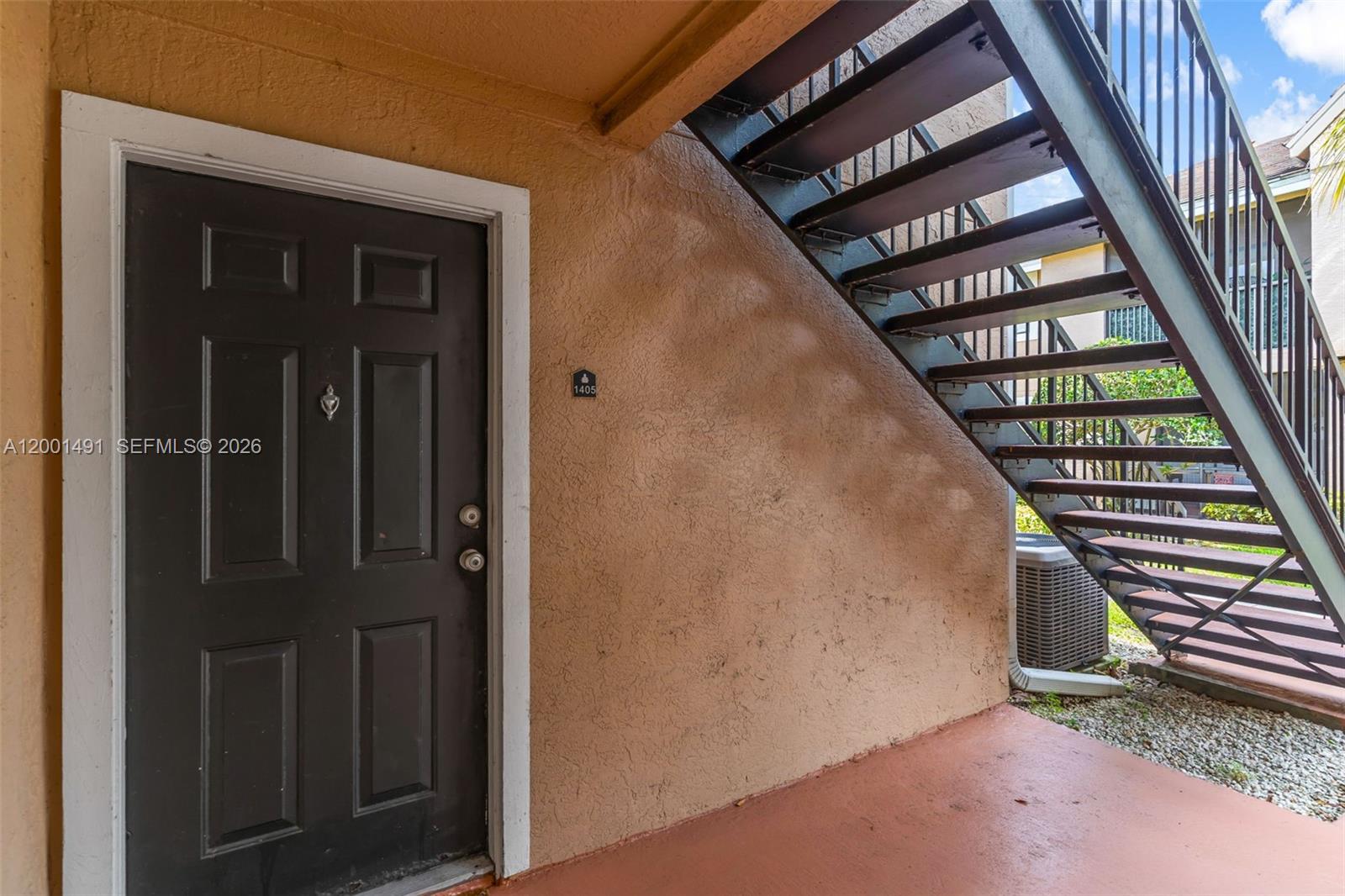 A dark brown door with a metal staircase leading to an upper level — 10680 SW 155th Pl # 1405, Miami FL 33196, MIAMI, FL