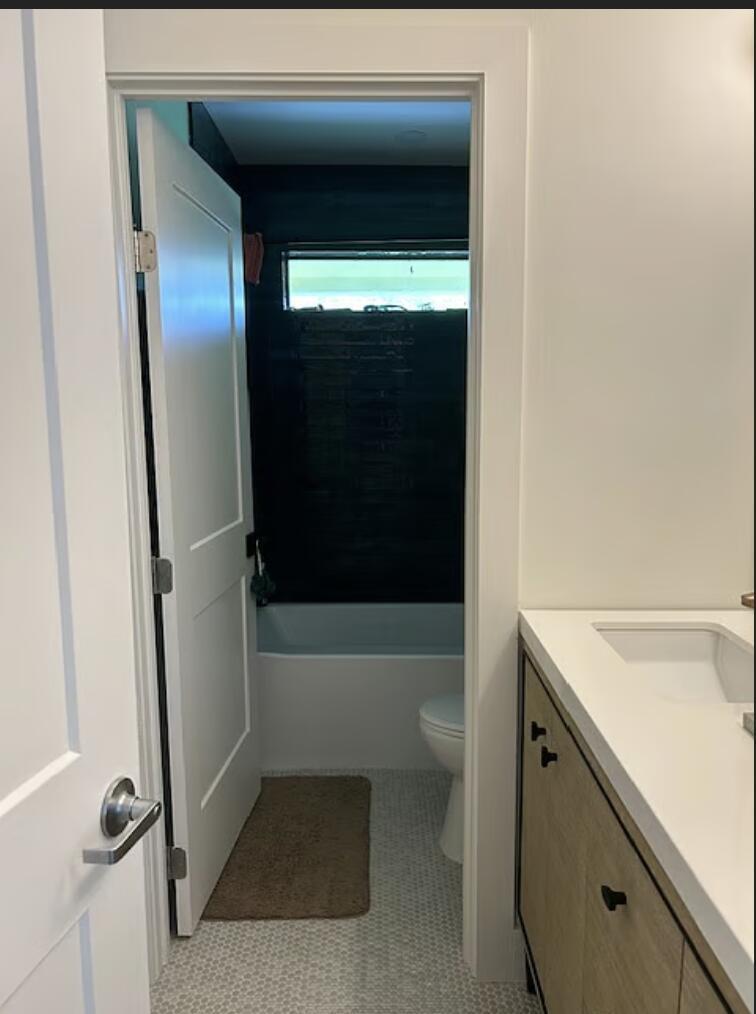 A view from a bathroom vanity area looking into a small room with a tub — 1822 Windsor # 1, FL 33408, FL