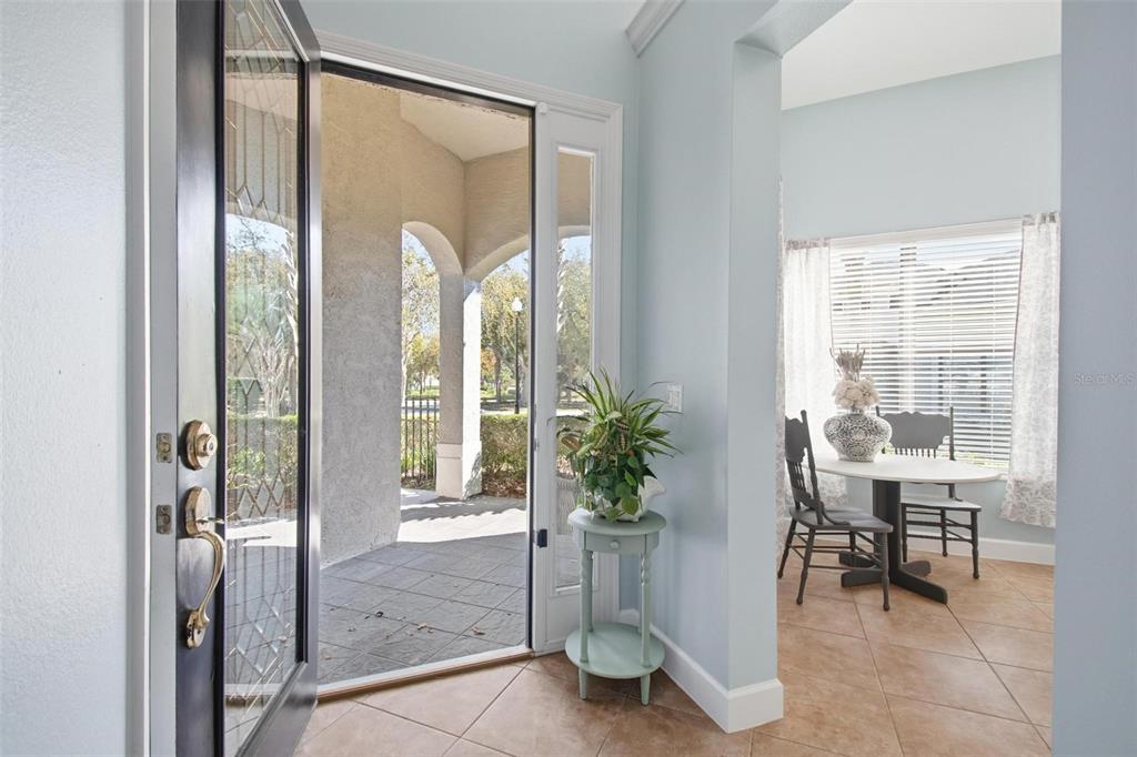 An open front door reveals a tiled entryway with a small table and dining area — 3 RIVER PARK DRIVE N, PALM COAST, FL