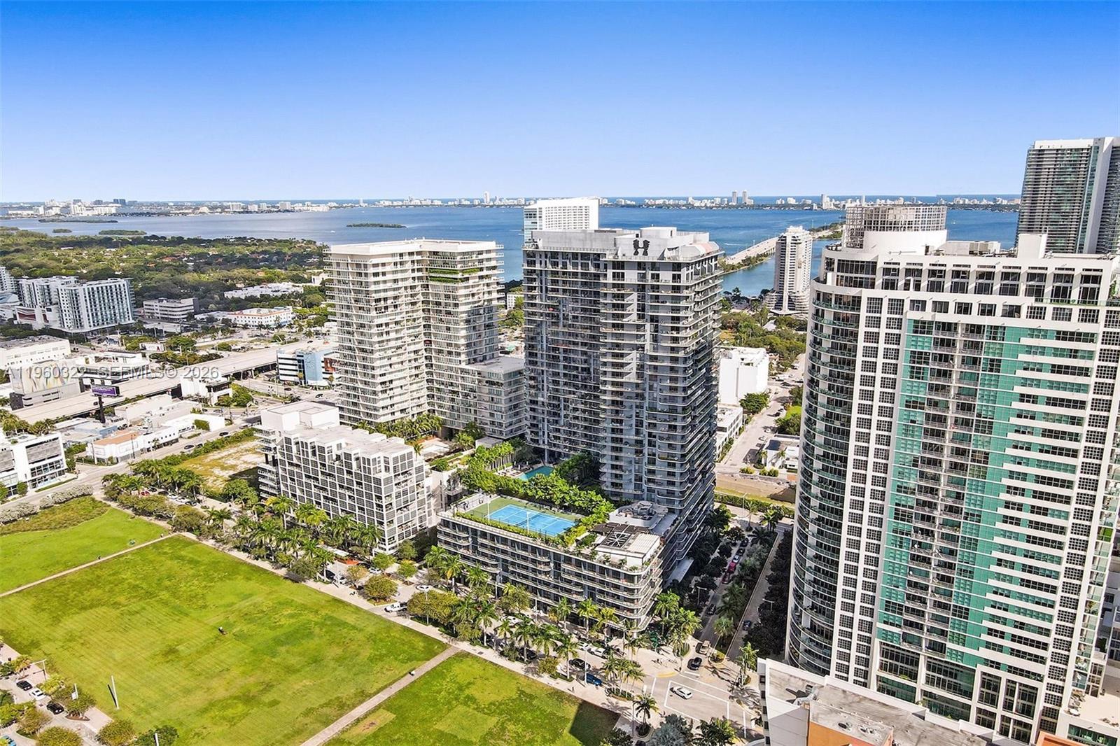 An aerial view of high-rise apartment buildings featuring a rooftop tennis court and swimming pool — 121 NE 34th St # 2305, Miami FL 33137, MIAMI, FL