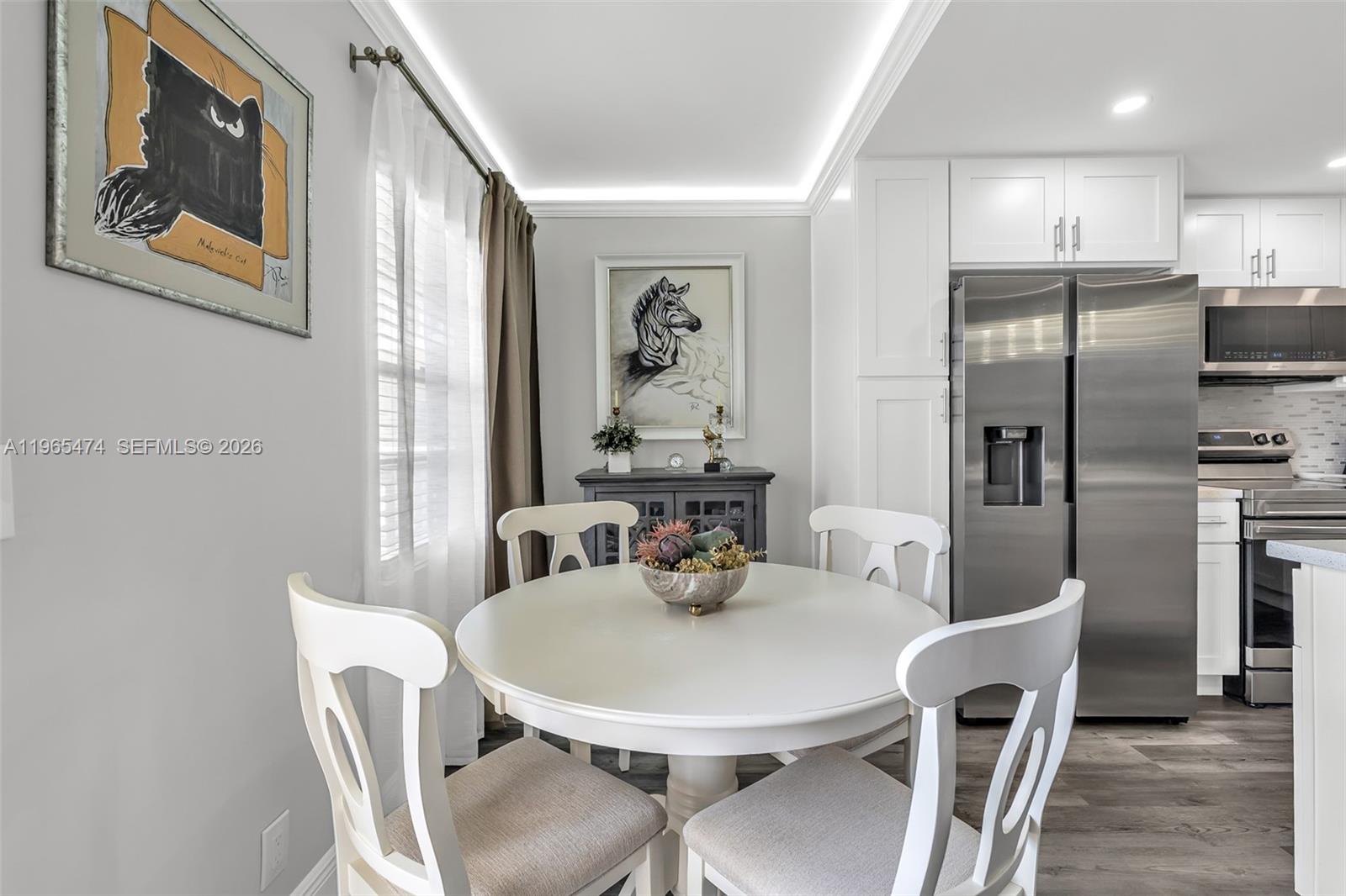 A dining area features a white round table, four chairs, and a stainless steel refrigerator — 152 Dorset D # 152, Boca Raton FL 33434, BOCA RATON, FL