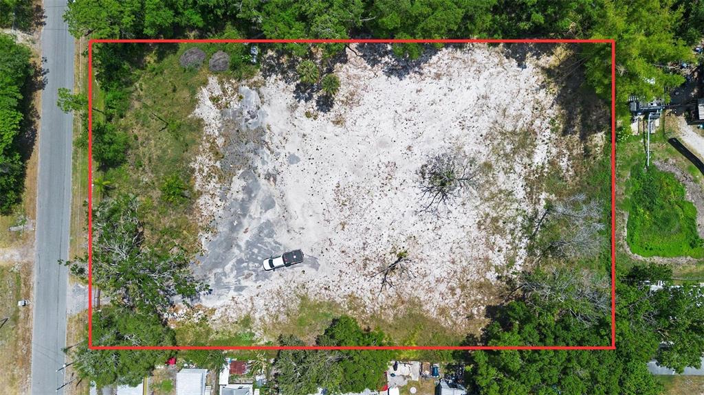 An aerial view shows a rectangular, cleared sandy lot surrounded by trees and a road — 17520 EVANS TRAIL, ORLANDO, FL