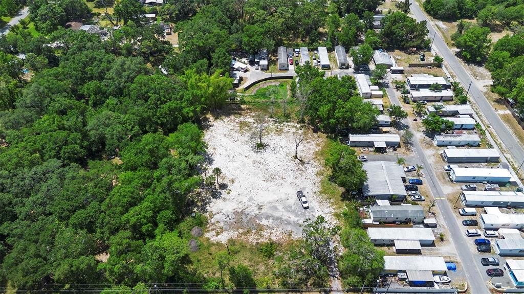 An aerial view shows a cleared, sandy lot bordered by trees and a mobile home park — 17520 EVANS TRAIL, ORLANDO, FL