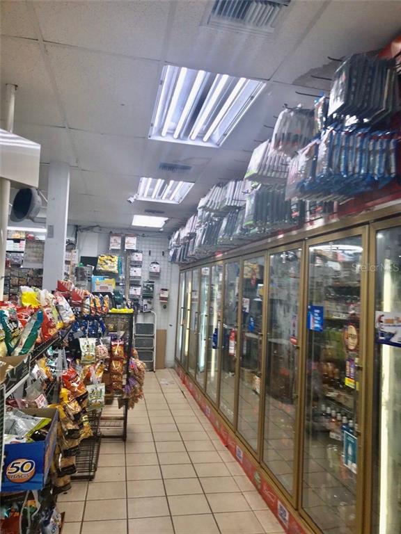 A convenience store aisle features tiled floors, fluorescent lighting, and rows of glass-front refrigerators — 1800 S FRENCH AVENUE, SANFORD, FL