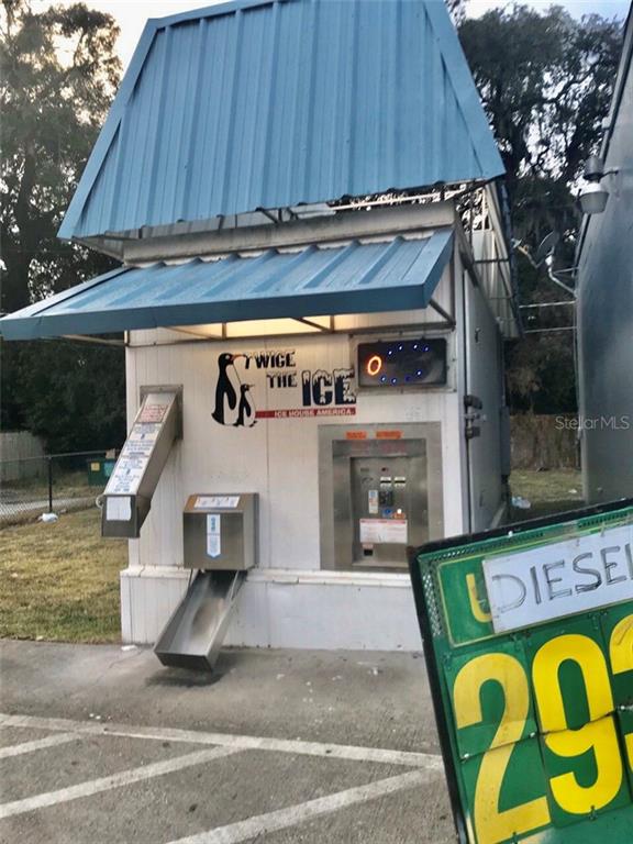 A standalone ice vending machine kiosk with a blue metal roof sits outdoors — 1800 S FRENCH AVENUE, SANFORD, FL