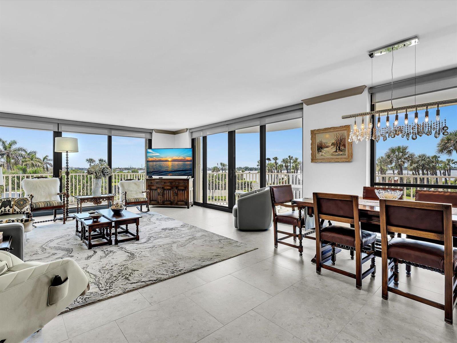 A bright living and dining area with tile floors, large windows, and views of palm trees — 3360 S Ocean Boulevard # 2a, Palm Beach FL 33480, PALM BEACH, FL