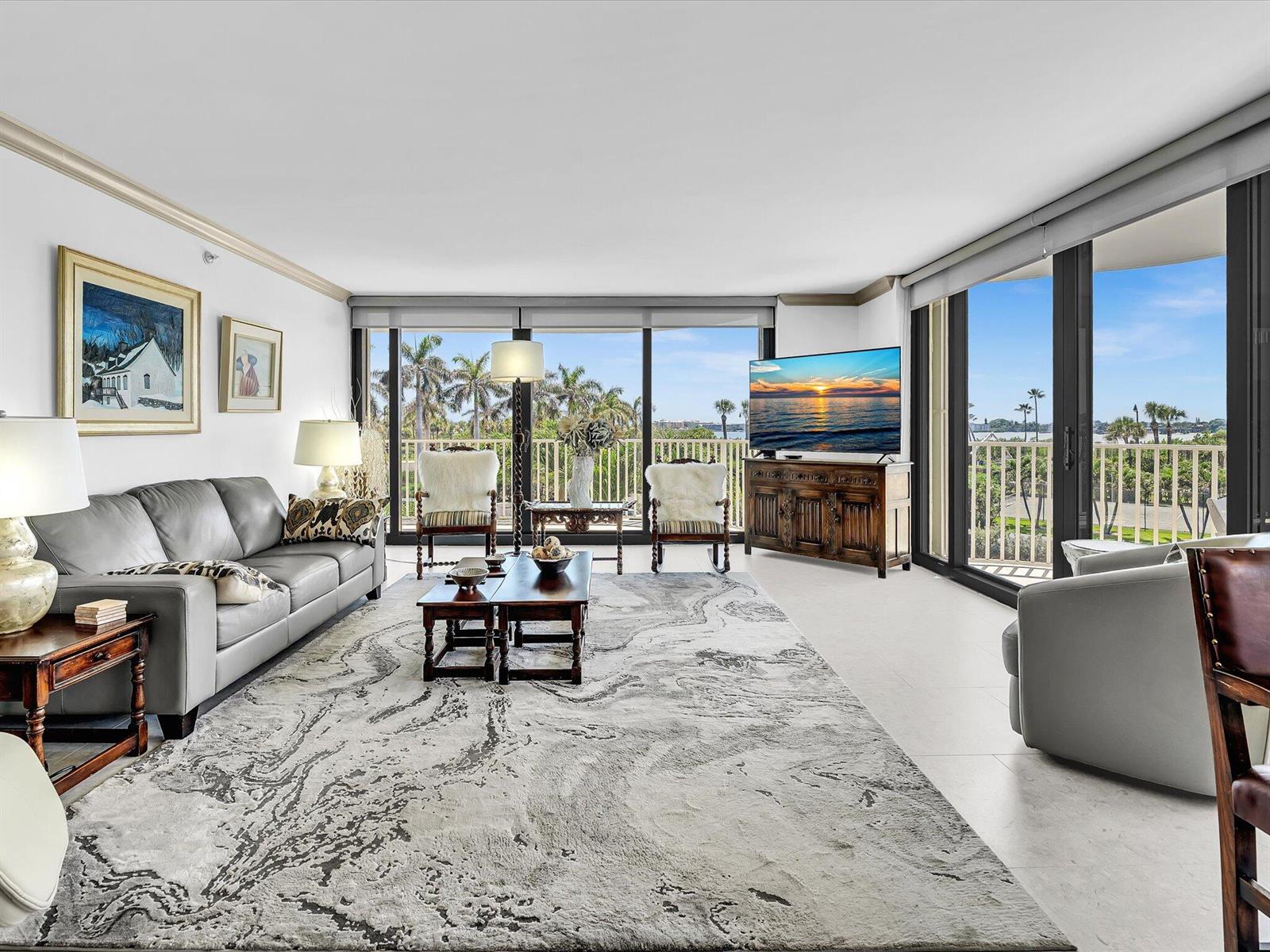 A living room features a grey sofa, patterned area rug, and floor-to-ceiling windows with views — 3360 S Ocean Boulevard # 2a, Palm Beach FL 33480, PALM BEACH, FL