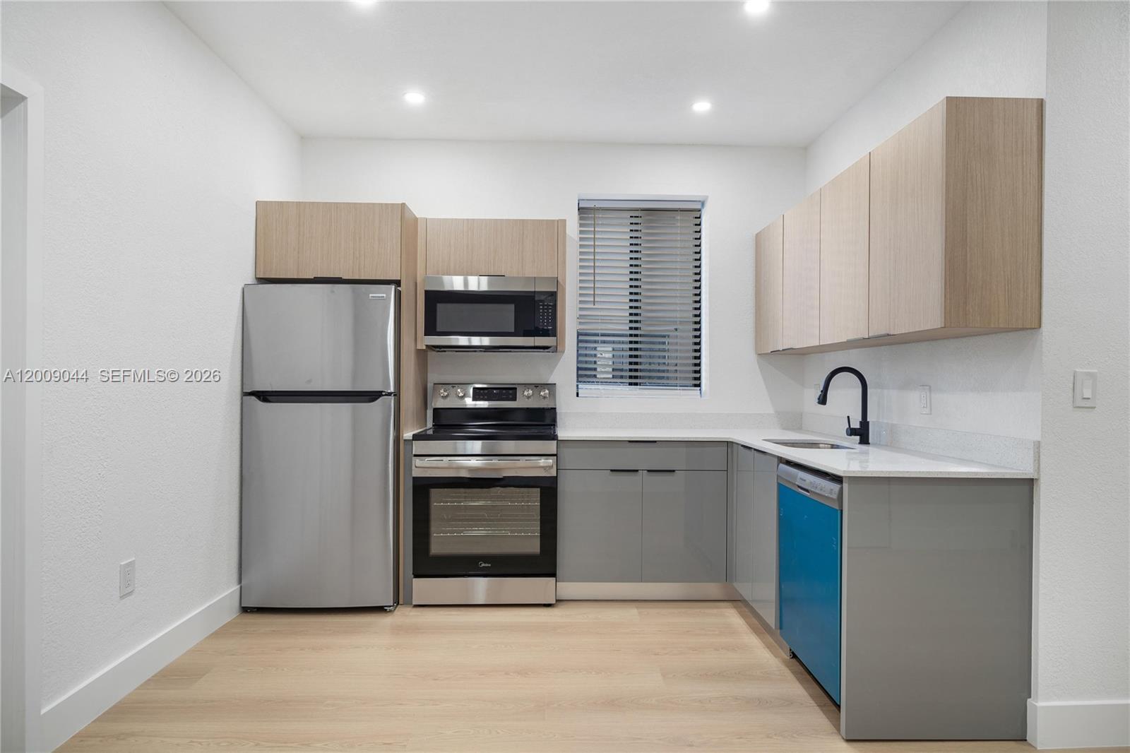 A kitchen features stainless steel appliances, grey lower cabinets, and light wood upper cabinets — 629 SW 10th Ave # 6, Miami FL 33130, MIAMI, FL