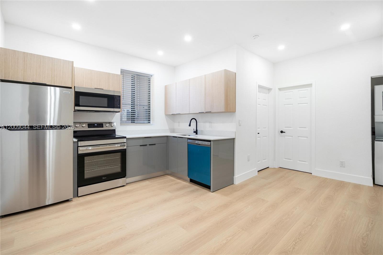 A kitchen features stainless steel appliances, gray lower cabinets, light wood upper cabinets, and flooring — 629 SW 10th Ave # 6, Miami FL 33130, MIAMI, FL