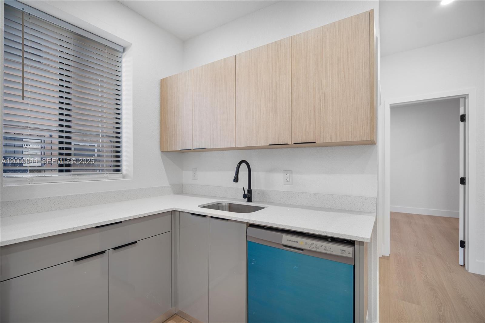 A laundry room features light wood upper cabinets, gray lower cabinets, and a stainless steel sink — 629 SW 10th Ave # 6, Miami FL 33130, MIAMI, FL