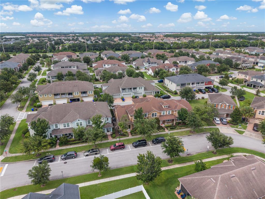 An aerial view shows two residential buildings with brown shingled roofs and adjacent parking spaces — 2569 FOLIO WAY, KISSIMMEE, FL