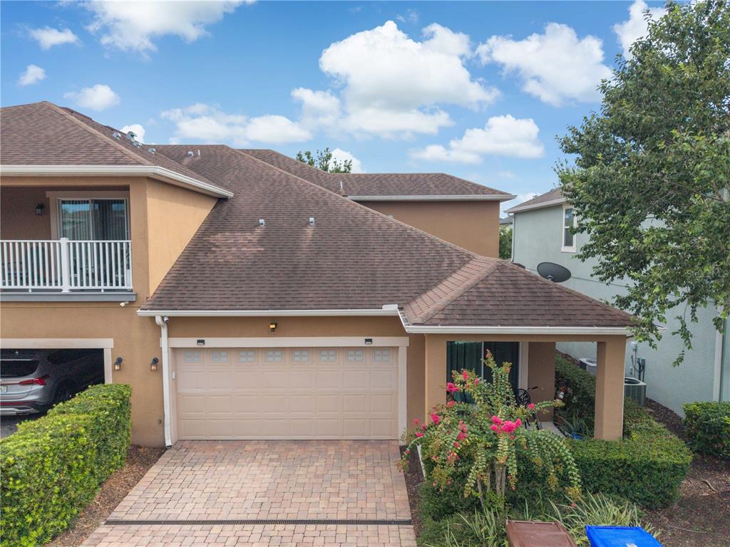 A covered front porch features two chairs, a door with a window, and a doormat — 2569 FOLIO WAY, KISSIMMEE, FL