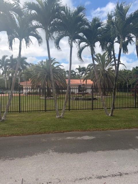 A single-story house with a tiled roof sits behind a black metal fence and palm trees — 7090 SW 62nd St # 0, Miami FL 33143, MIAMI, FL