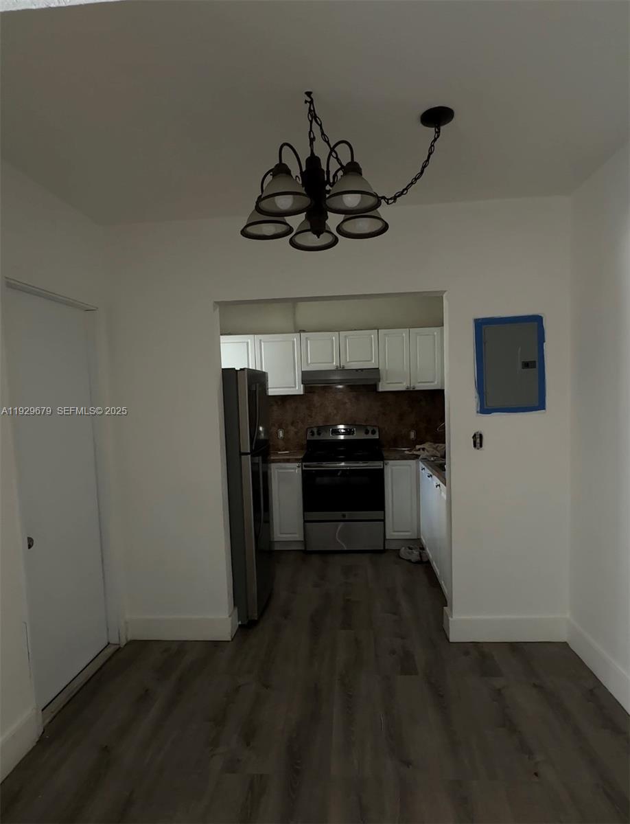 A kitchen with white cabinets and stainless steel appliances is viewed from an adjacent room — 1895 Venice Park Dr # A18, Miami FL 33181, MIAMI, FL