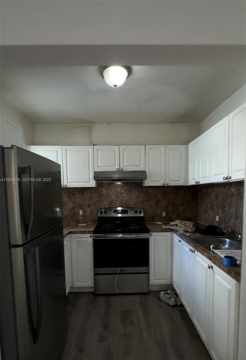 A kitchen features white cabinets, stainless steel appliances, and a brown backsplash — 1895 Venice Park Dr # A18, Miami FL 33181, MIAMI, FL