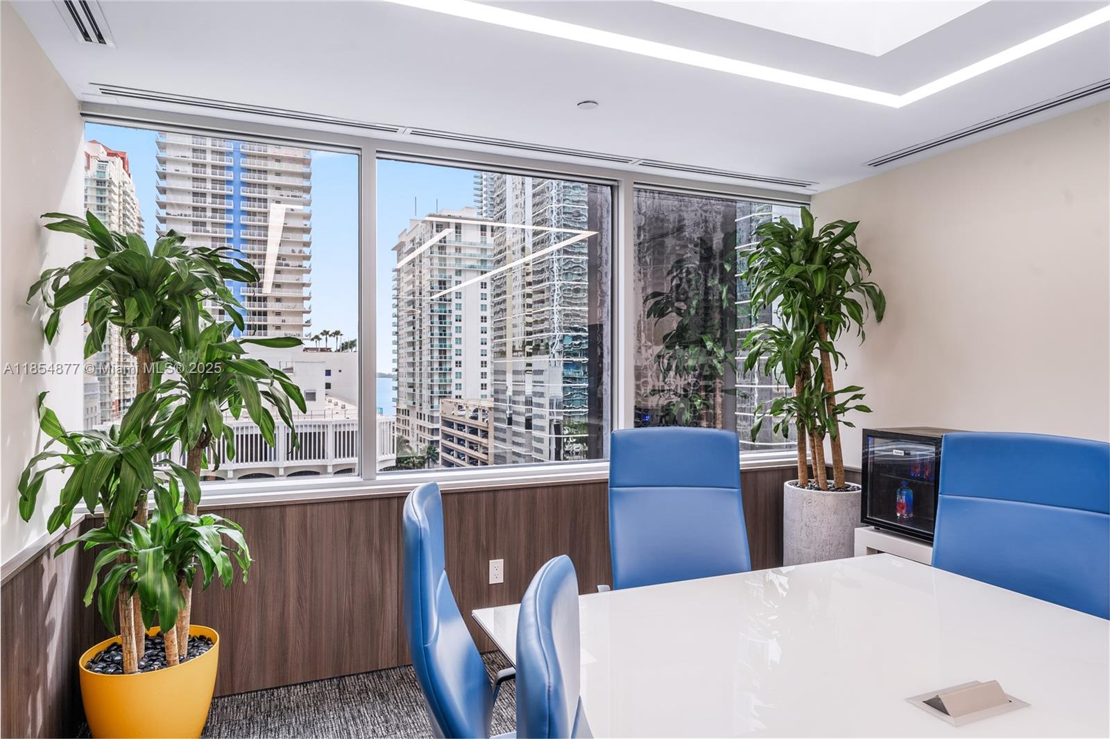 A modern office conference room features blue chairs, a white table, and city skyline views — 1200 Brickell Ave # A, Miami FL 33131, MIAMI, FL