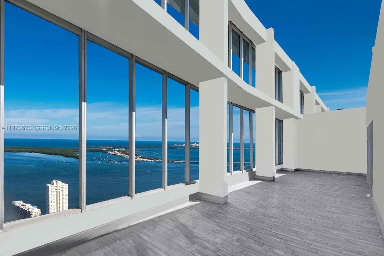 A modern balcony with gray tile flooring overlooks a coastal bay and city skyline — 465 Brickell Ave # 5701, Miami FL 33131, MIAMI, FL