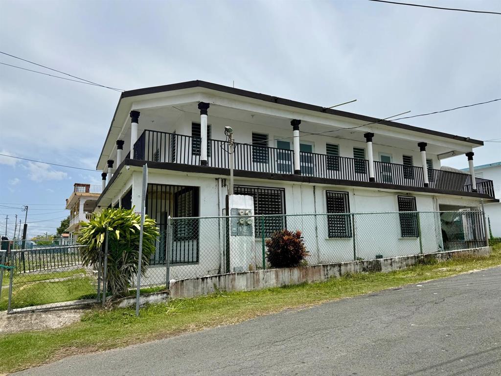 A two-story white building with a wrap-around balcony and black metal railings — 53 CALLE SATURNO COM SANDIN UNIT 1, VEGA BAJA, PR