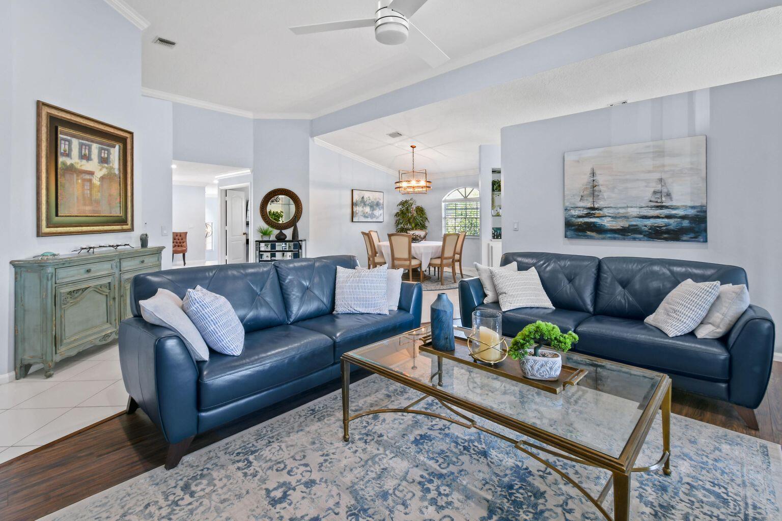A living room features two blue leather sofas, a glass coffee table, and a dining area — 252 Legendary Circle, Palm Beach Gardens FL 33418, PALM BEACH GARDENS, FL