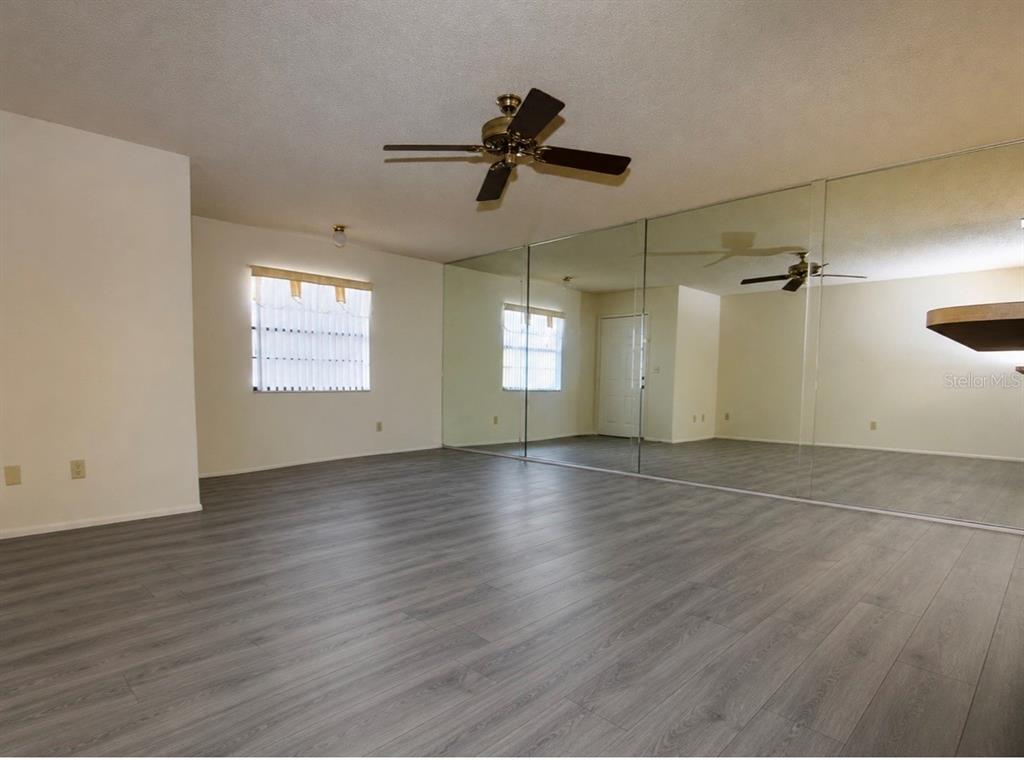 A single-story house with a screened-in porch and palm trees on a grassy lot — 4161 66TH STREET CIRCLE W, BRADENTON, FL
