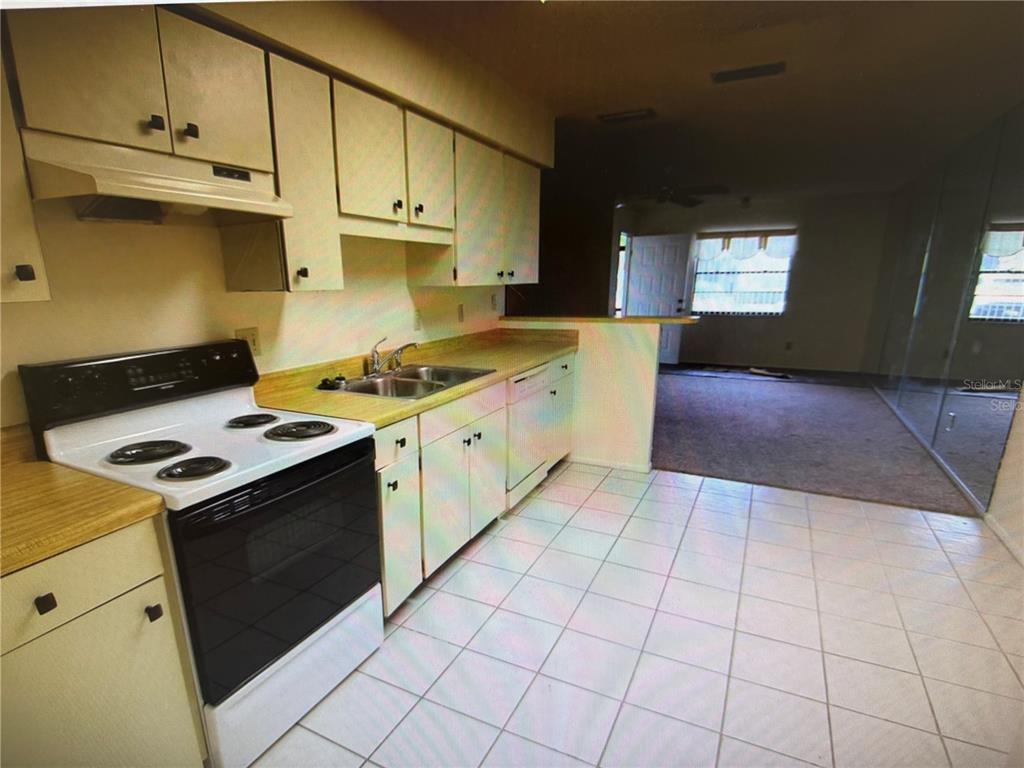 A screened-in patio features a stone floor, light-colored siding, and a sliding glass door — 4161 66TH STREET CIRCLE W, BRADENTON, FL