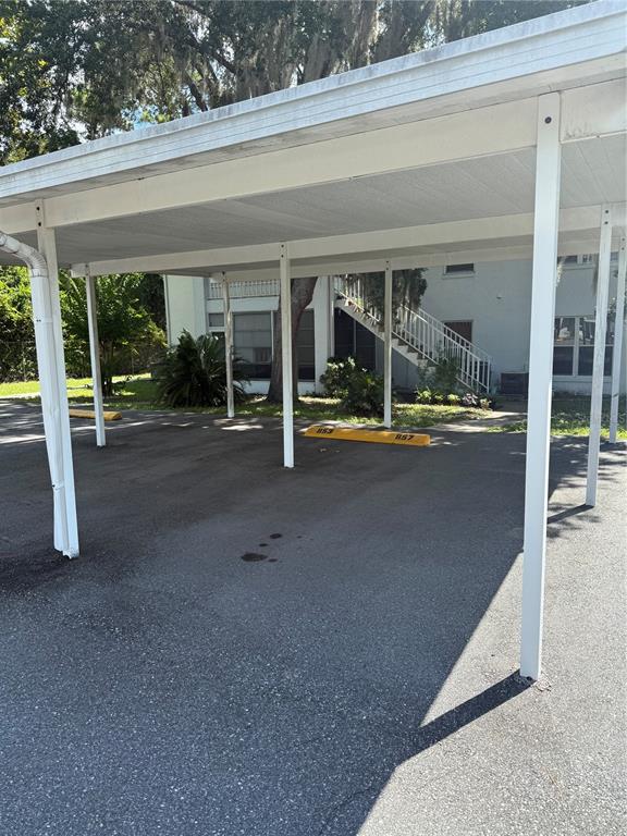 A covered parking carport with numbered concrete wheel stops in front of an apartment building — 857 SE MAYO DRIVE UNIT 102, CRYSTAL RIVER, FL