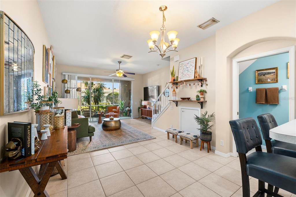 A living room with tile floors, a ceiling fan, and a staircase leading to a loft — 5357 60TH AVENUE N, ST PETERSBURG, FL