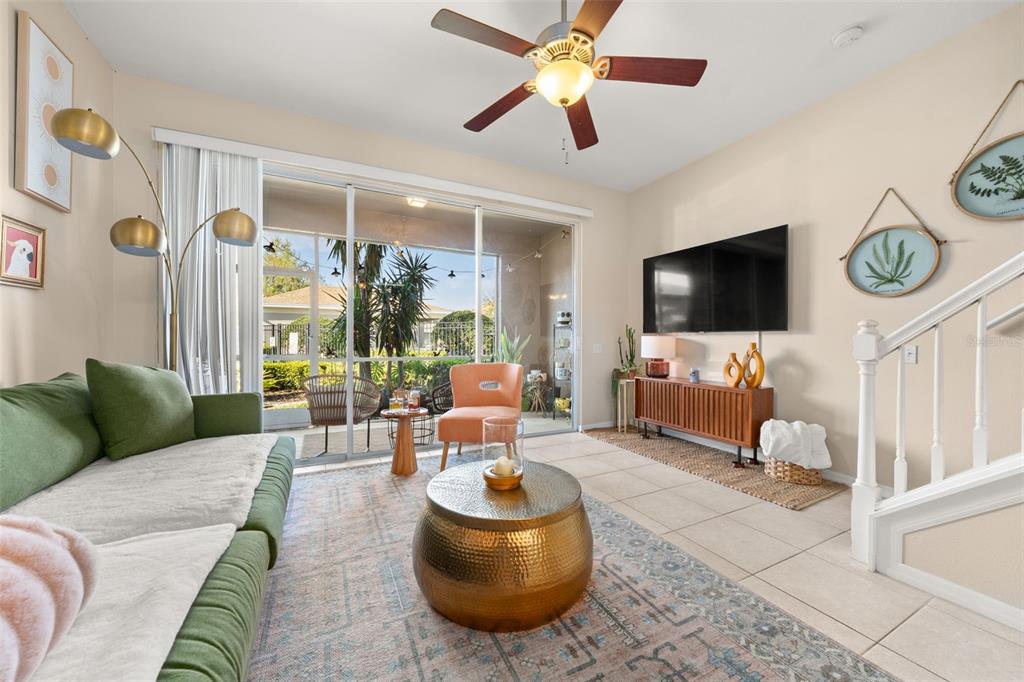 A living room features a green sofa, gold coffee table, television, and sliding glass doors — 5357 60TH AVENUE N, ST PETERSBURG, FL