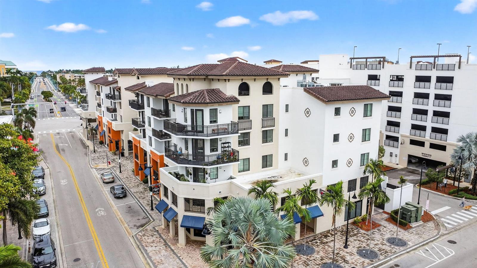 An aerial view shows a multi-story Mediterranean-style apartment building with balconies and a parking garage — 510 E Ocean Avenue # 102, Boynton Beach FL 33435, BOYNTON BEACH, FL