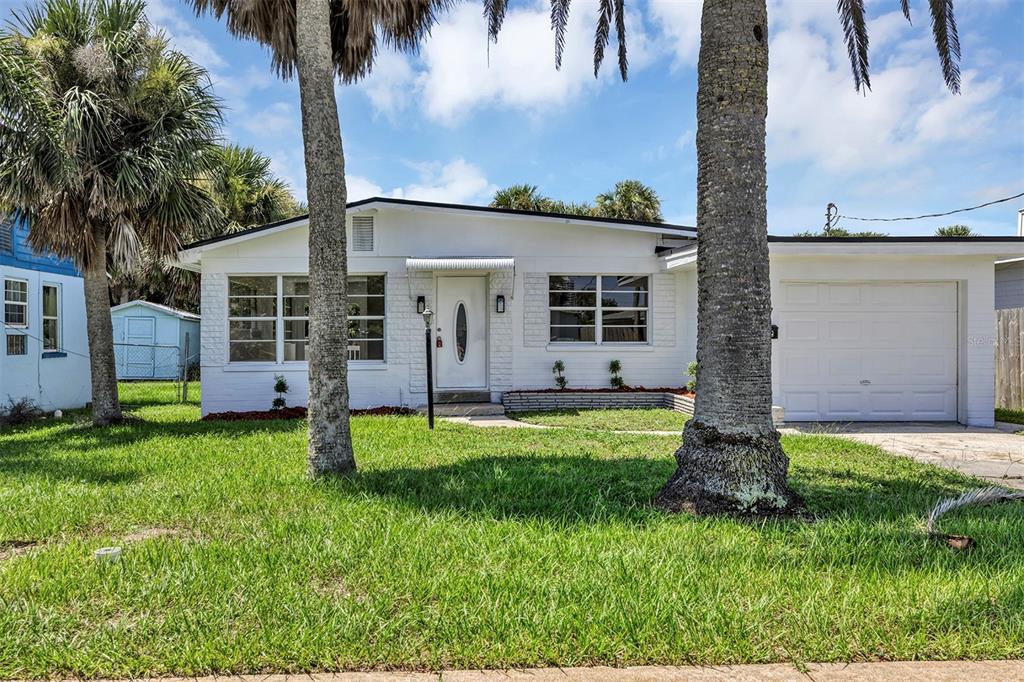 A white, single-story house with a garage and palm trees in the front yard — 332 WILLIAMS AVENUE, DAYTONA BEACH, FL