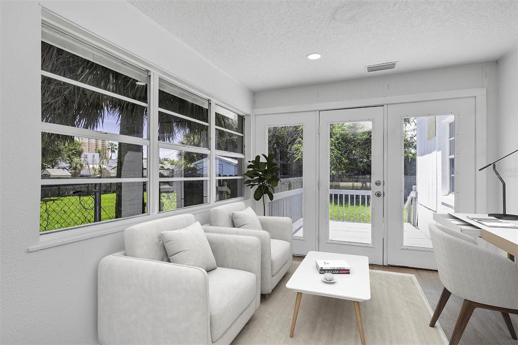 A sunroom features white walls, two armchairs, a coffee table, and a desk with chairs — 332 WILLIAMS AVENUE, DAYTONA BEACH, FL