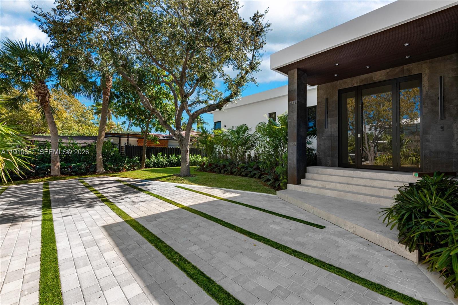 A modern house entrance features a paved driveway with grass strips and stone steps — 270 N Shore Dr, Miami Beach FL 33141, MIAMI BEACH, FL