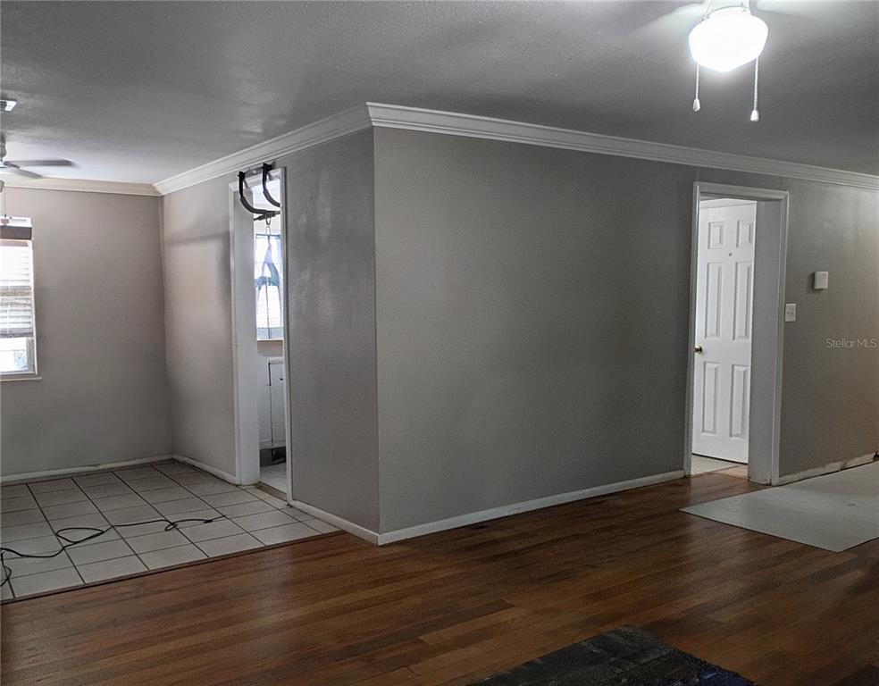 An interior view shows a room with hardwood floors, tiled flooring, and gray walls — 2601 MANATEE HARBOR DRIVE, RUSKIN, FL