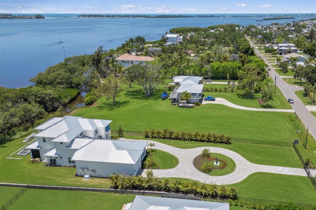 An aerial view of a large white house with a metal roof and circular driveway — 9912 46TH AVENUE W, BRADENTON, FL