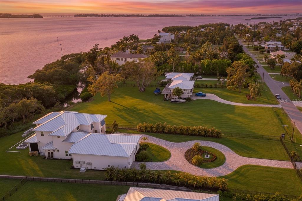 An aerial view of a waterfront property featuring a large house with a metal roof — 9912 46TH AVENUE W, BRADENTON, FL