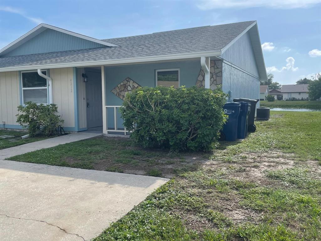 A single-story house with blue and beige siding features a small porch and stone accents — 4212 78TH STREET W UNIT 4212, BRADENTON, FL