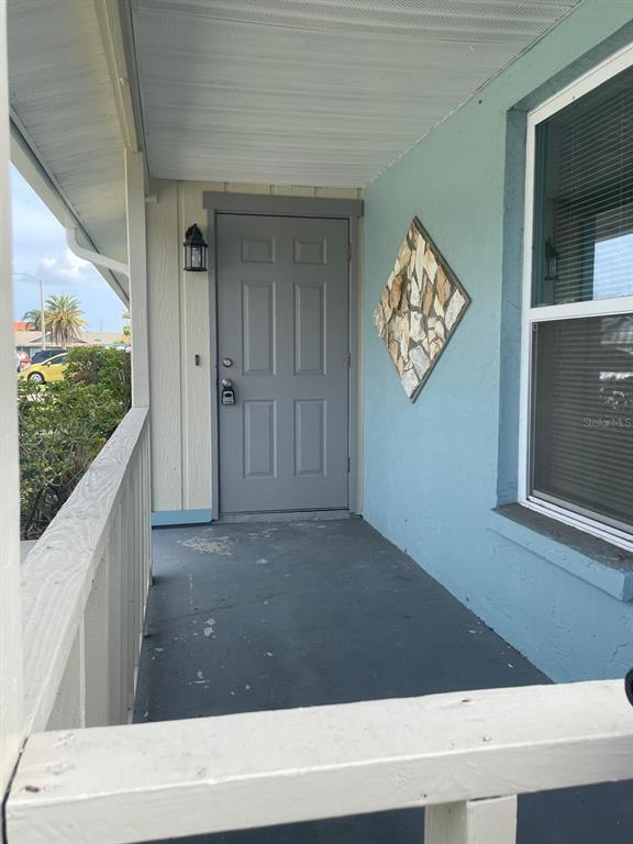 A covered front porch features a gray door, light blue siding, and a decorative stone accent — 4212 78TH STREET W UNIT 4212, BRADENTON, FL
