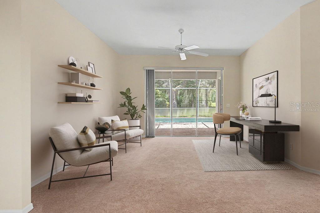 This virtually staged room features a desk, two chairs, wall shelving, and sliding glass doors — 9009 SW 194TH COURT, DUNNELLON, FL