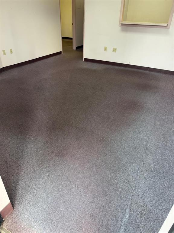 An empty office room features gray carpet flooring, white walls, and a small service window — 6000 STATE ROAD 544, WINTER HAVEN, FL