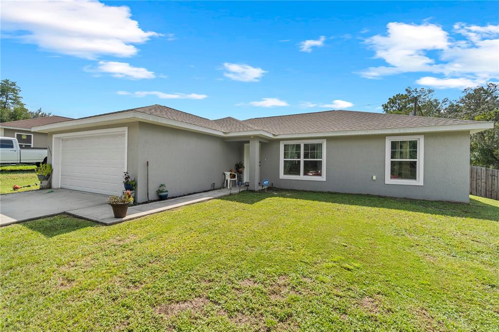 A single-story gray house with a two-car garage and a front lawn — 14626 SW 79TH TERRACE ROAD, OCALA, FL