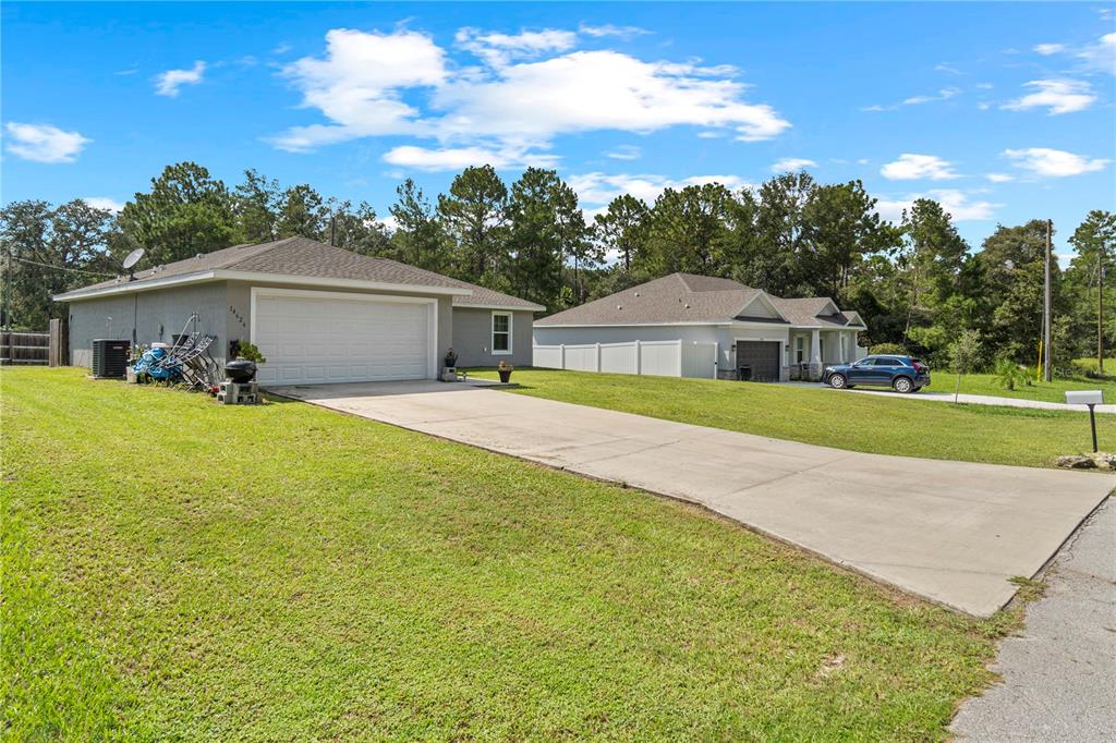 A single-story gray house with a two-car garage and a white vinyl fence — 14626 SW 79TH TERRACE ROAD, OCALA, FL