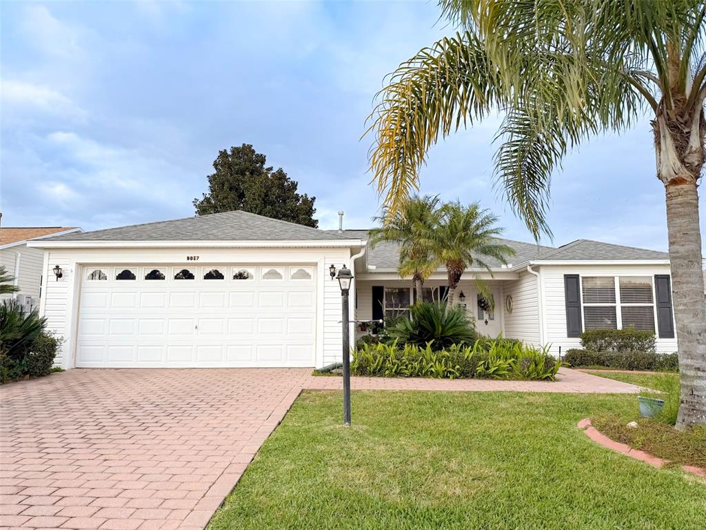 A single-story house with white siding, a two-car garage, and a paved driveway — 8017 SE 175TH COLUMBIA PLACE, THE VILLAGES, FL