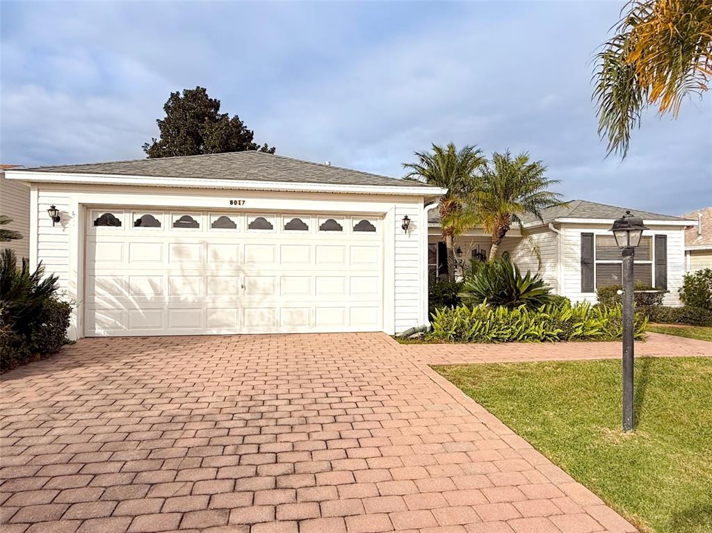 A single-story house with white siding, a two-car garage, and a brick paver driveway — 8017 SE 175TH COLUMBIA PLACE, THE VILLAGES, FL