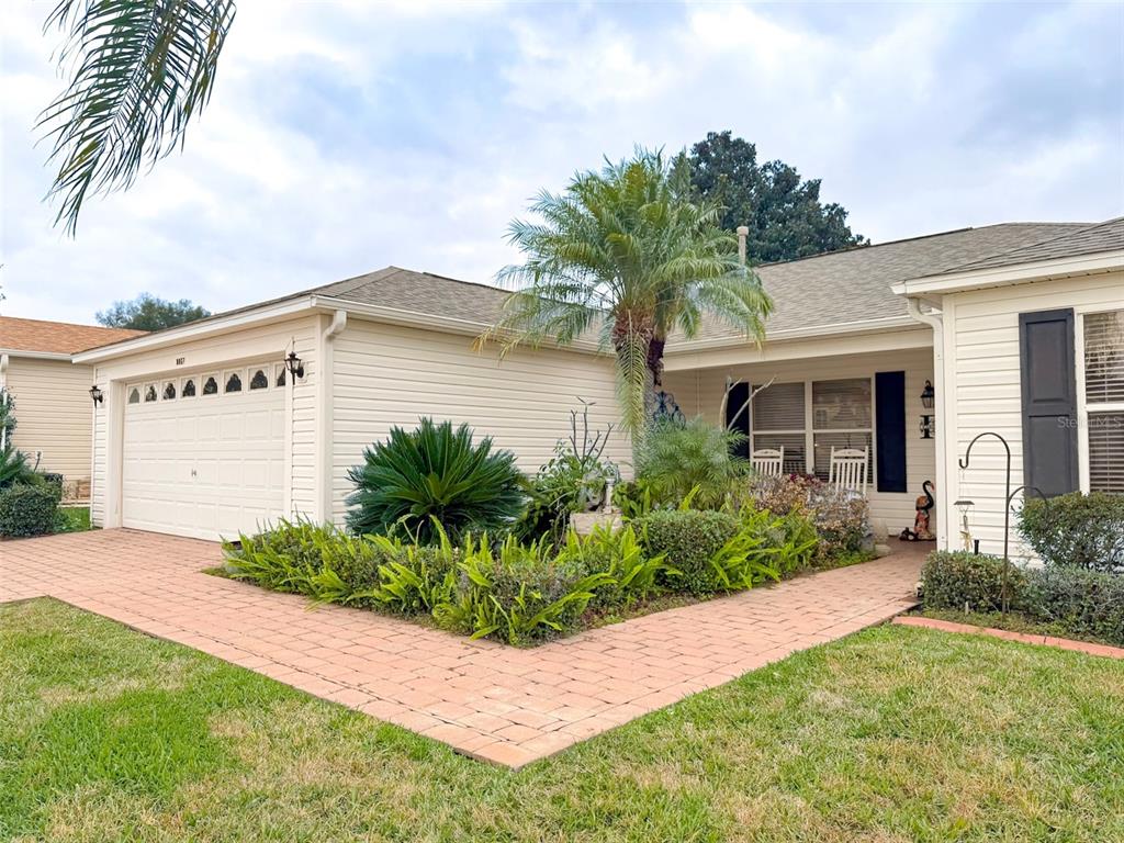 A single-story house with beige siding, a two-car garage, and a brick walkway — 8017 SE 175TH COLUMBIA PLACE, THE VILLAGES, FL
