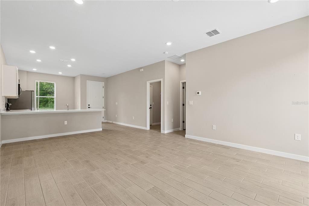 An open-concept living area features light-colored tile flooring, recessed lighting, and a kitchen island — 2499 SW 167TH LOOP, OCALA, FL