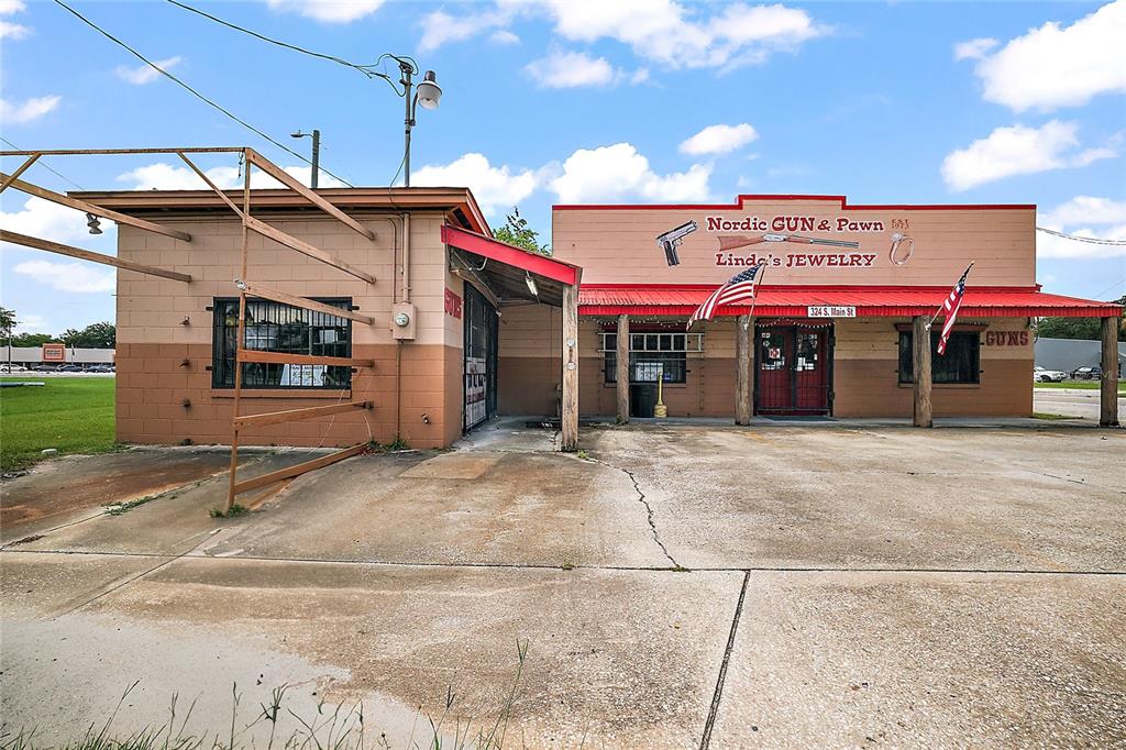 The exterior of a single-story commercial building features a gun and pawn shop sign — 324 S MAIN STREET, WILDWOOD, FL