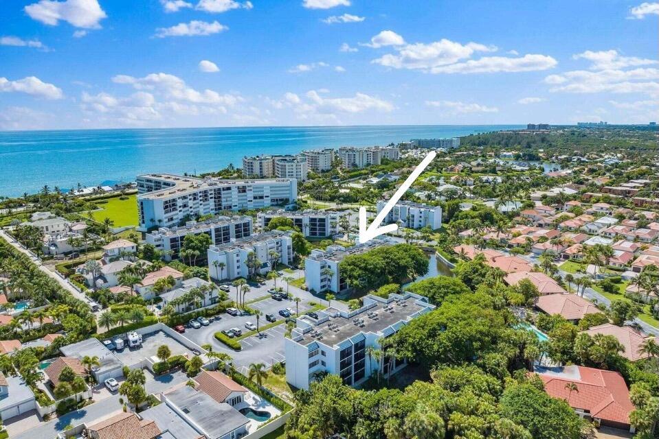 An aerial view shows a multi-story apartment building surrounded by trees and a parking lot — 1605 S Us Highway 1 # C302, Jupiter FL 33477, JUPITER, FL