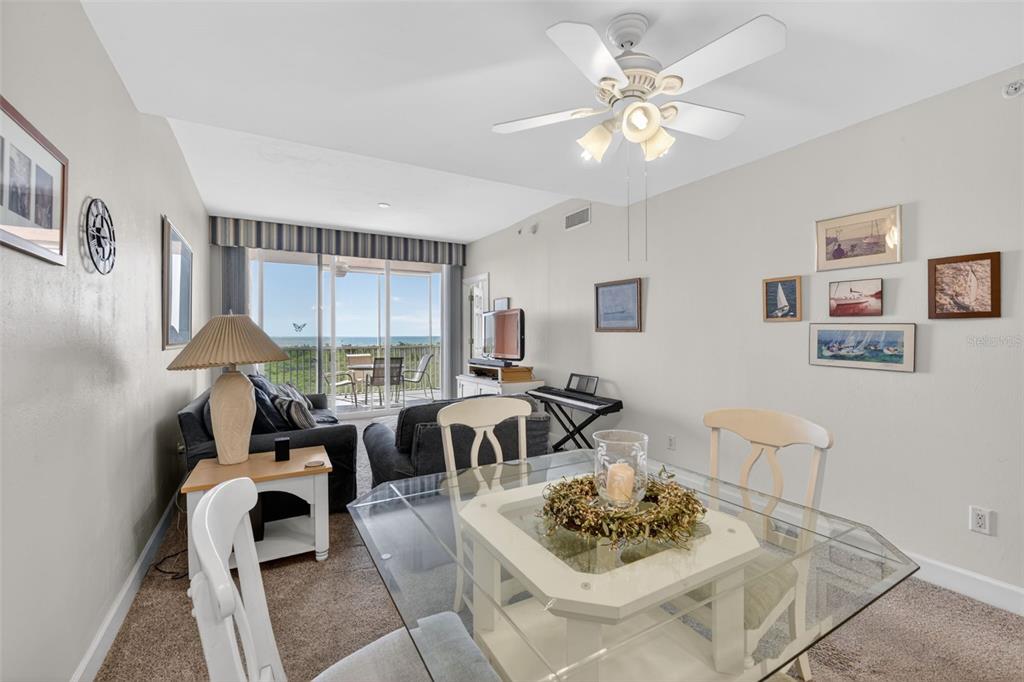 A dining area with a glass table opens to a living room with ocean views — 3191 MATECUMBE KEY ROAD UNIT 304, PUNTA GORDA, FL
