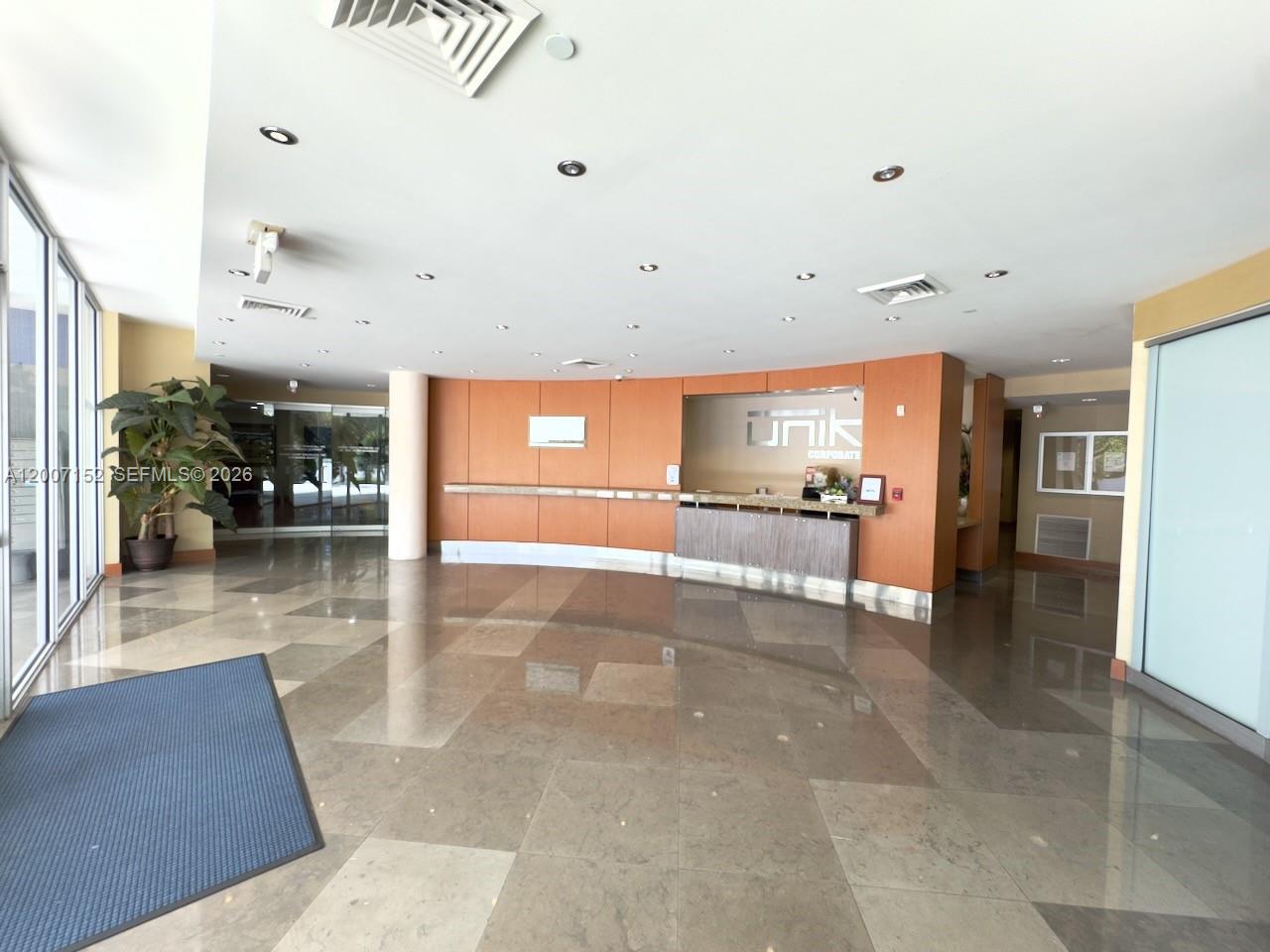 A spacious office lobby features a reception desk, wood-paneled walls, and polished tile flooring — 4300 Biscayne Blvd # 206, Miami FL 33137, MIAMI, FL