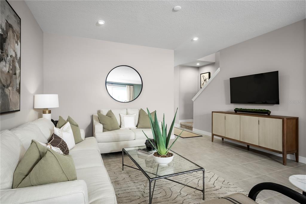 A living room features a white sofa, a loveseat, a glass coffee table, and television — 20462 LOU ANGELA LANE, LUTZ, FL